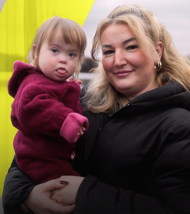 Isabel hält ihre kleine Tochter auf dem Arm. Links im Bild sieht man Isabel in der Schwangerschaft. Sie fasst sich an ihren schwangeren Bauch - ihr Oberteil ist dabei hochgezogen. 