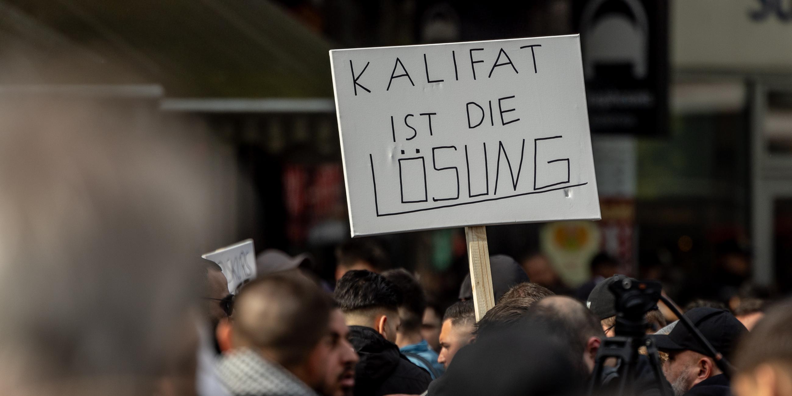 Hamburg: Teilnehmer einer Islamisten-Demo halten ein Plakat mit der Aufschrift "Kalifat ist die Lösung" in die Höhe