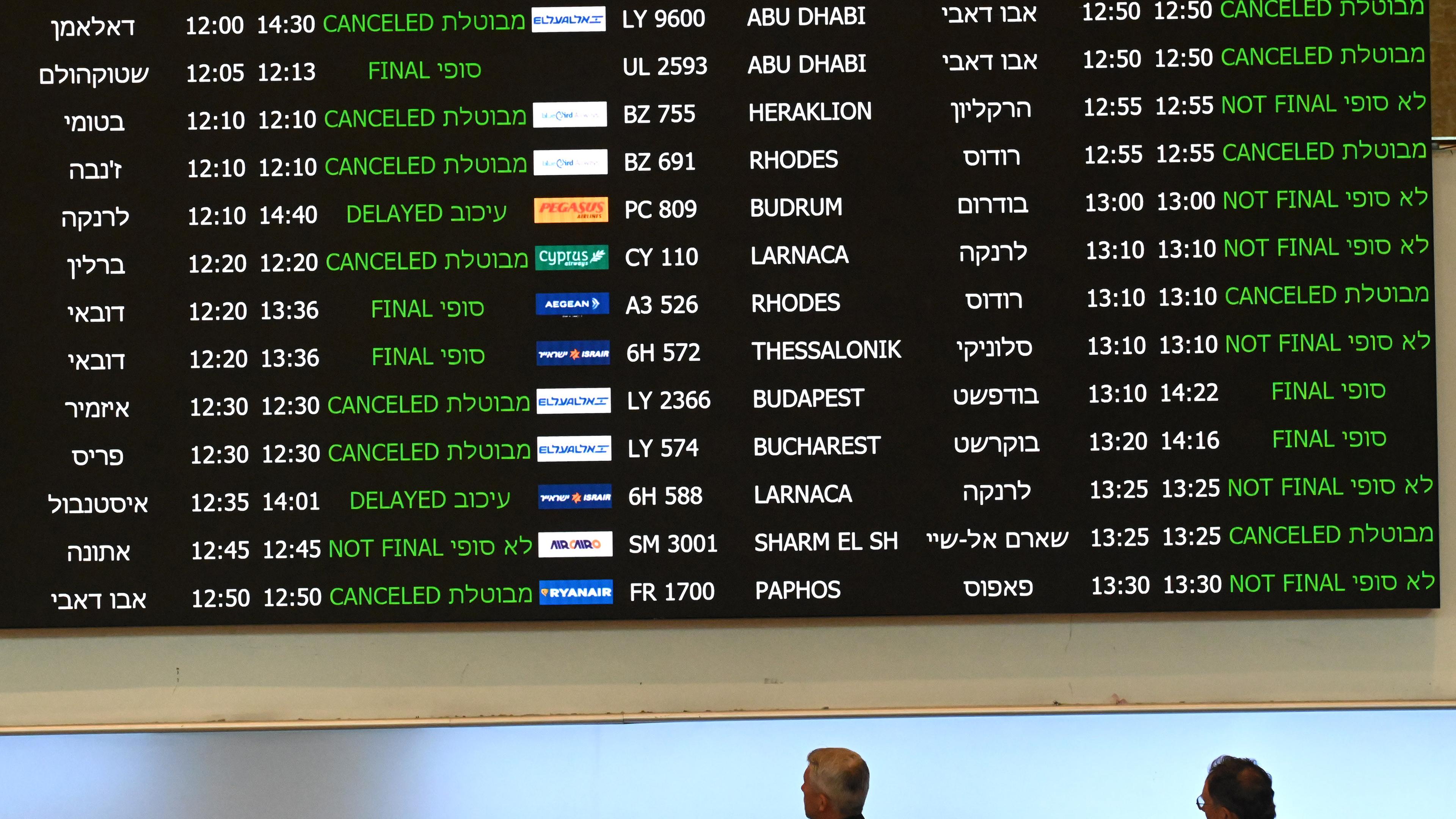 People look at an arrival board for canceled flights in Ben Gurion Airport near Tel Aviv, on Sunday, October 8, 2023. 