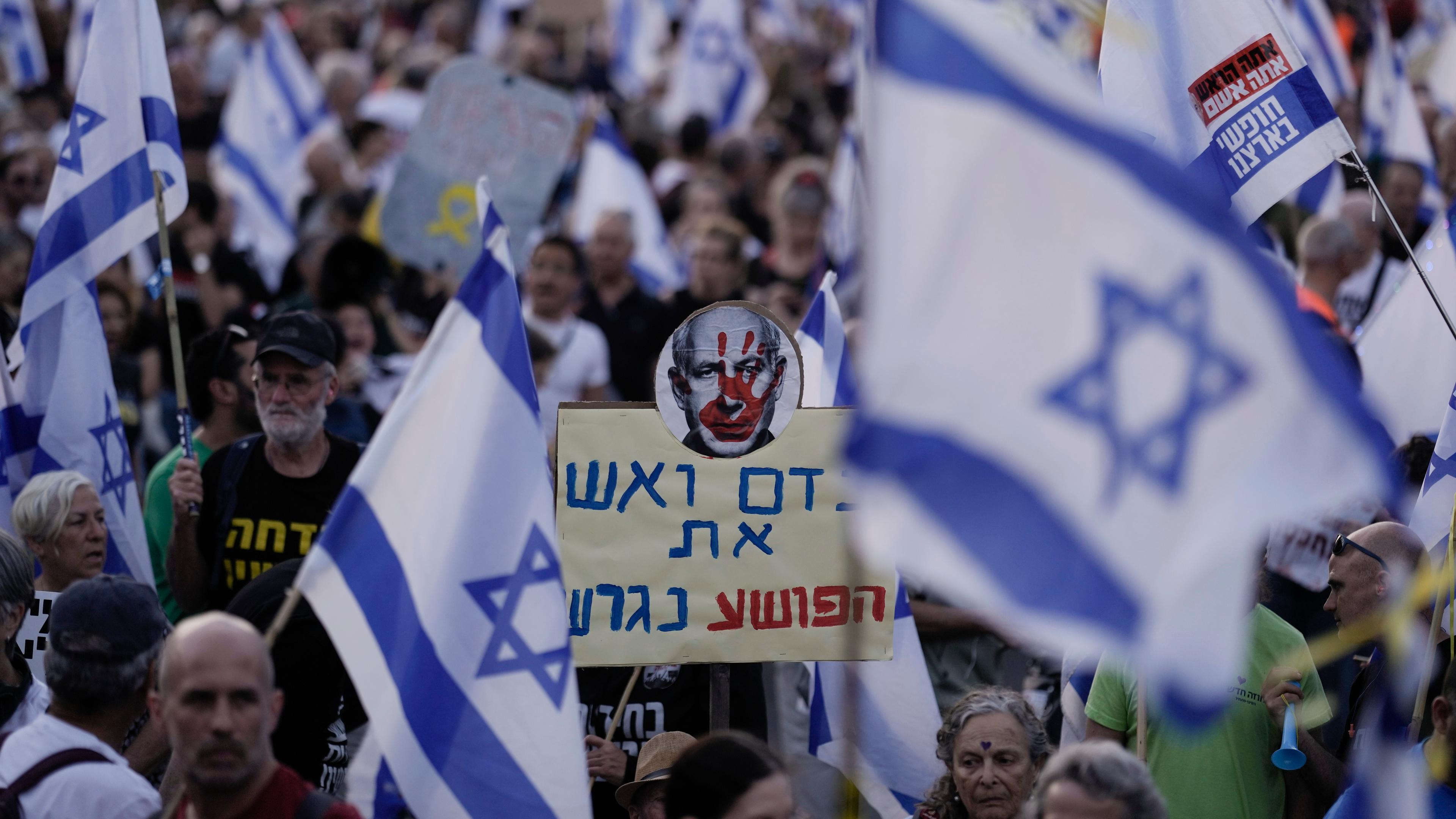  Israel, Jerusalem: Menschen demonstrieren vor der Knesset gegen die Regierung des israelischen Ministerpräsidenten Netanjahu.