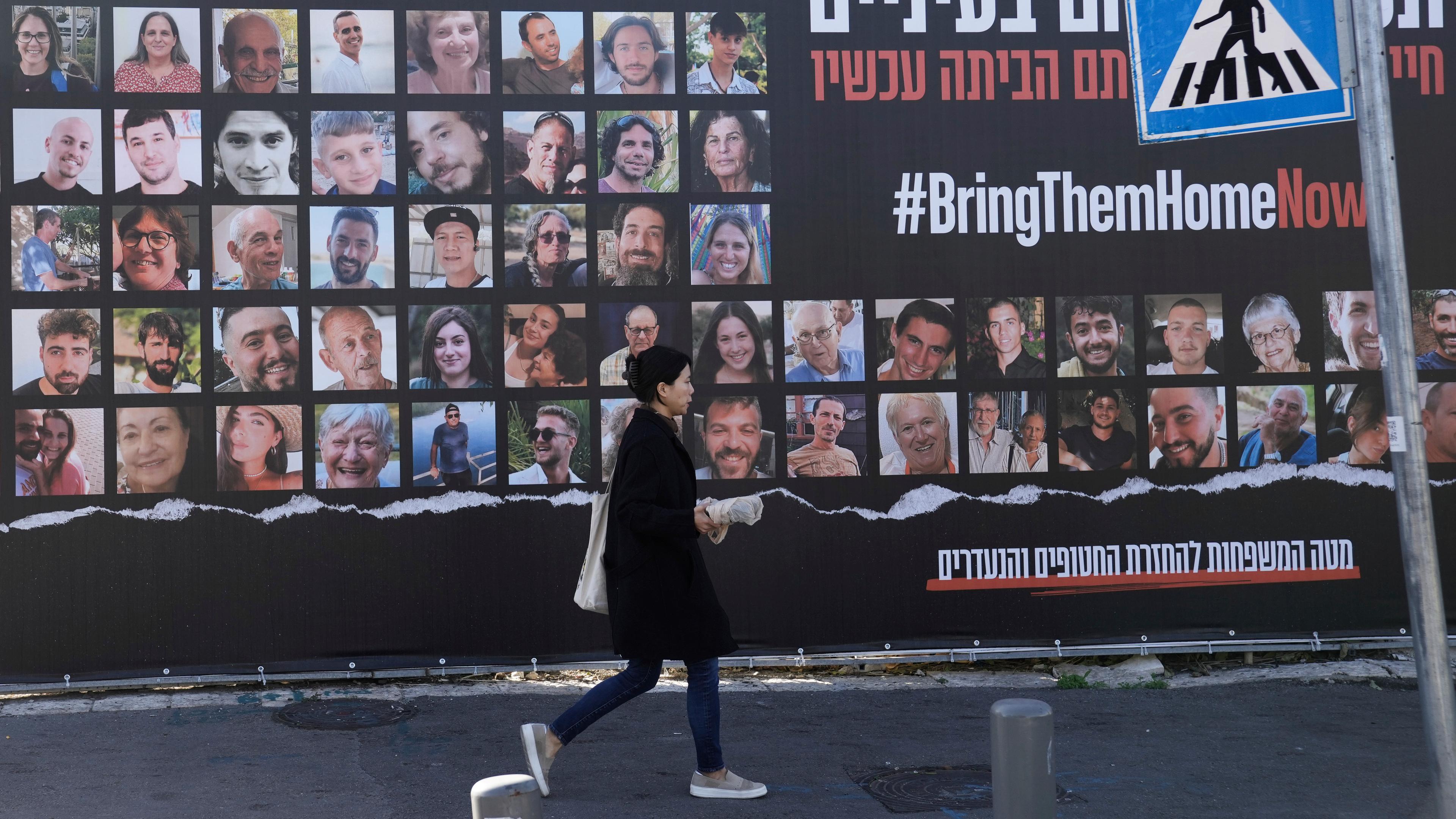  Eine Frau geht in Jerusalem an einem Plakat vorbei, das die Rückkehr von etwa 240 Geiseln fordert, die während des Hamas-Angriffs auf Israel am 7. Oktober entführt worden waren. 