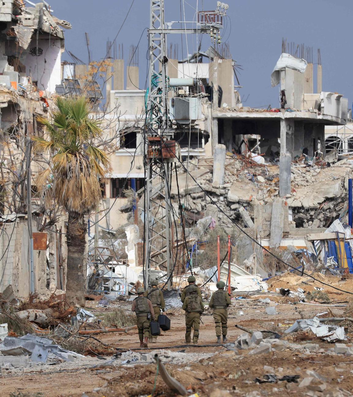 Israelische Soldaten laufen durch Trümmer