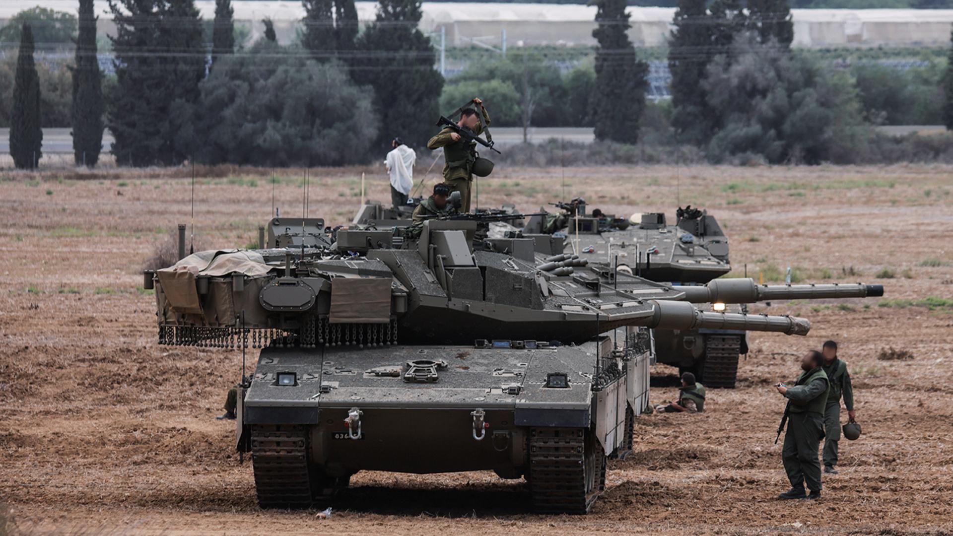 Zu sehen ist ein Panzer im Gelände sowie israelische Soldaten. 