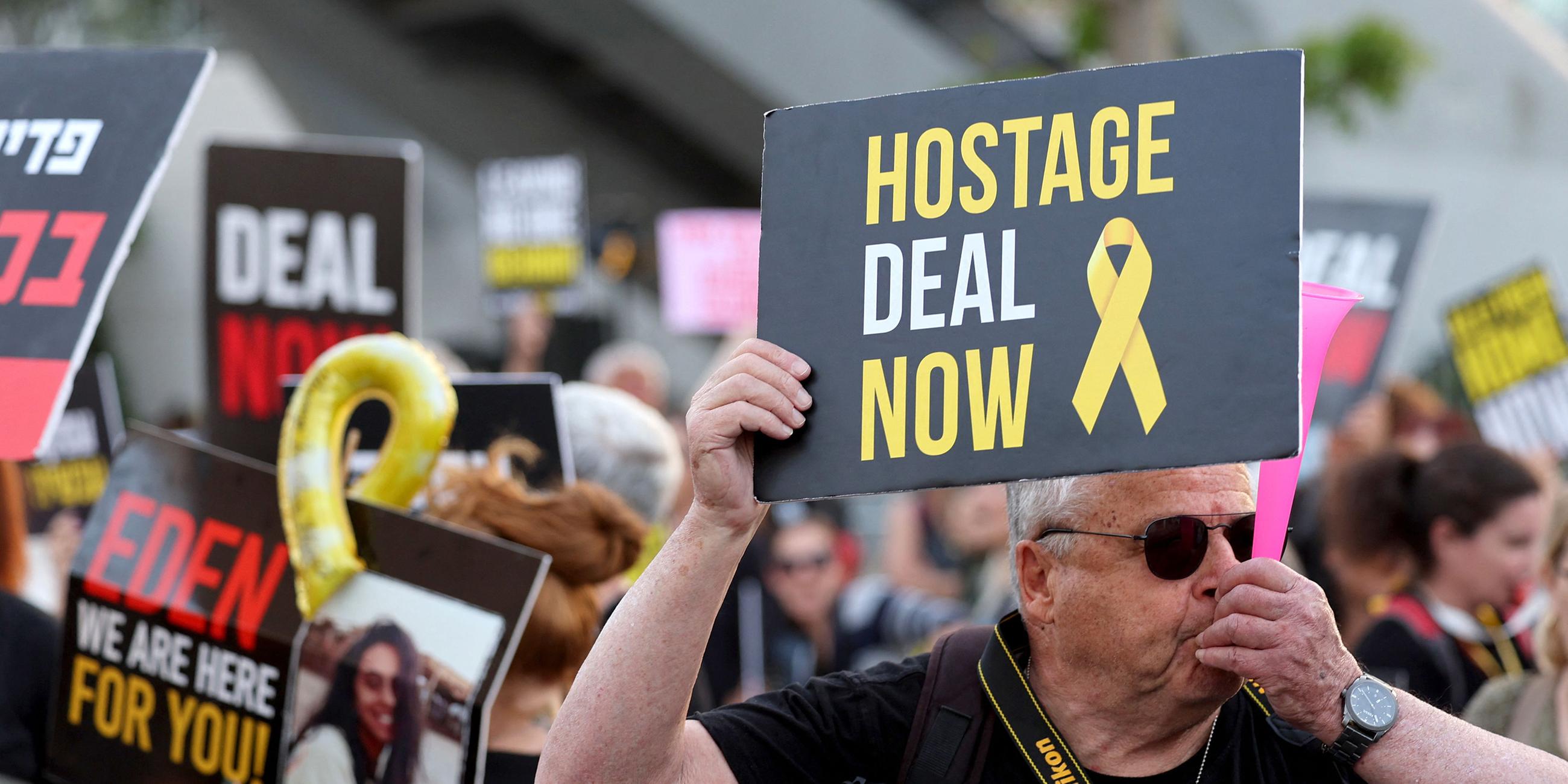 Demonstrant hält Schild mit der Schrift: "Hostage deal now" in Tel Aviv, Israel