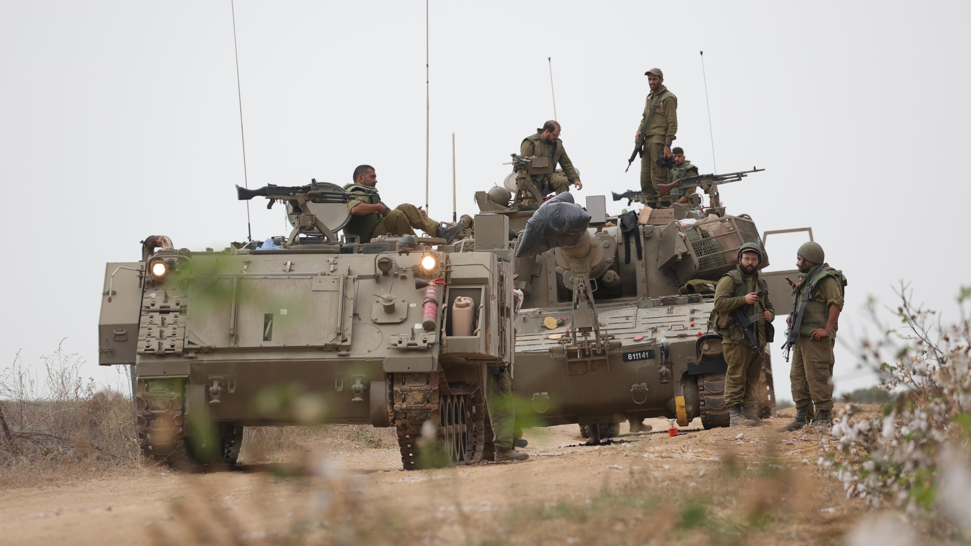 Israelische Soldaten stehen auf und um zwei Panzern.