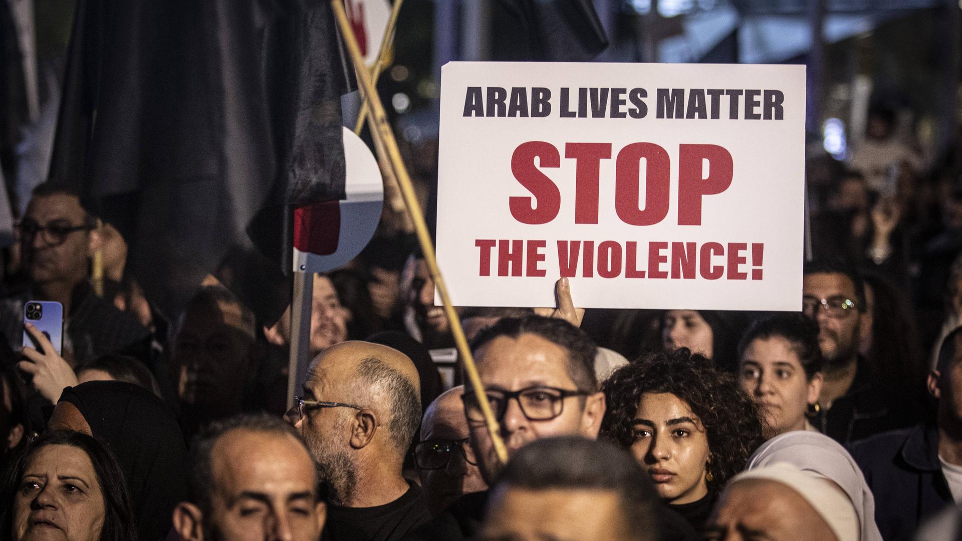 Ein Protestiernder hält ein Plakat mit der Aufschrift "Arab Lives Matter. Stop The Violence!"