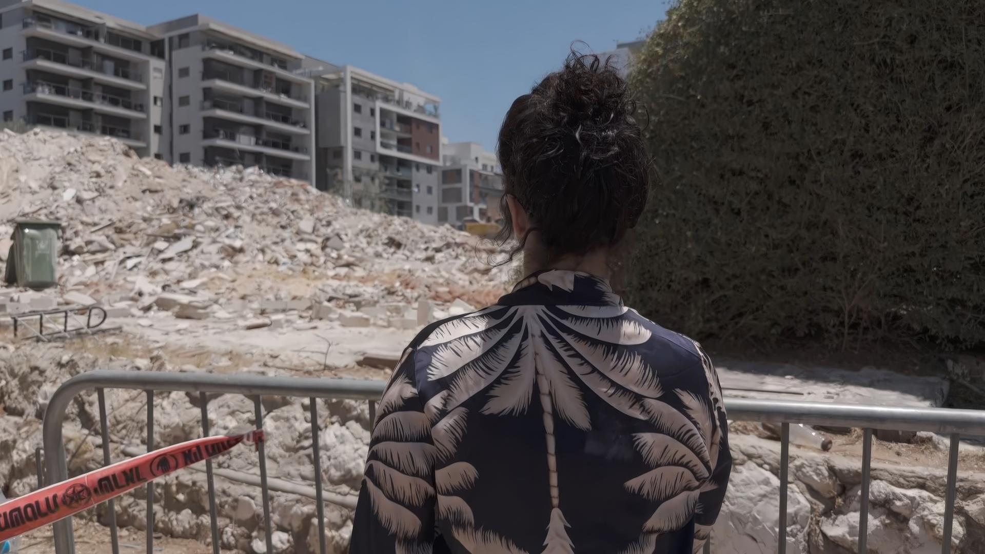 Mutter schaut auf zerstörtes Haus in Israel