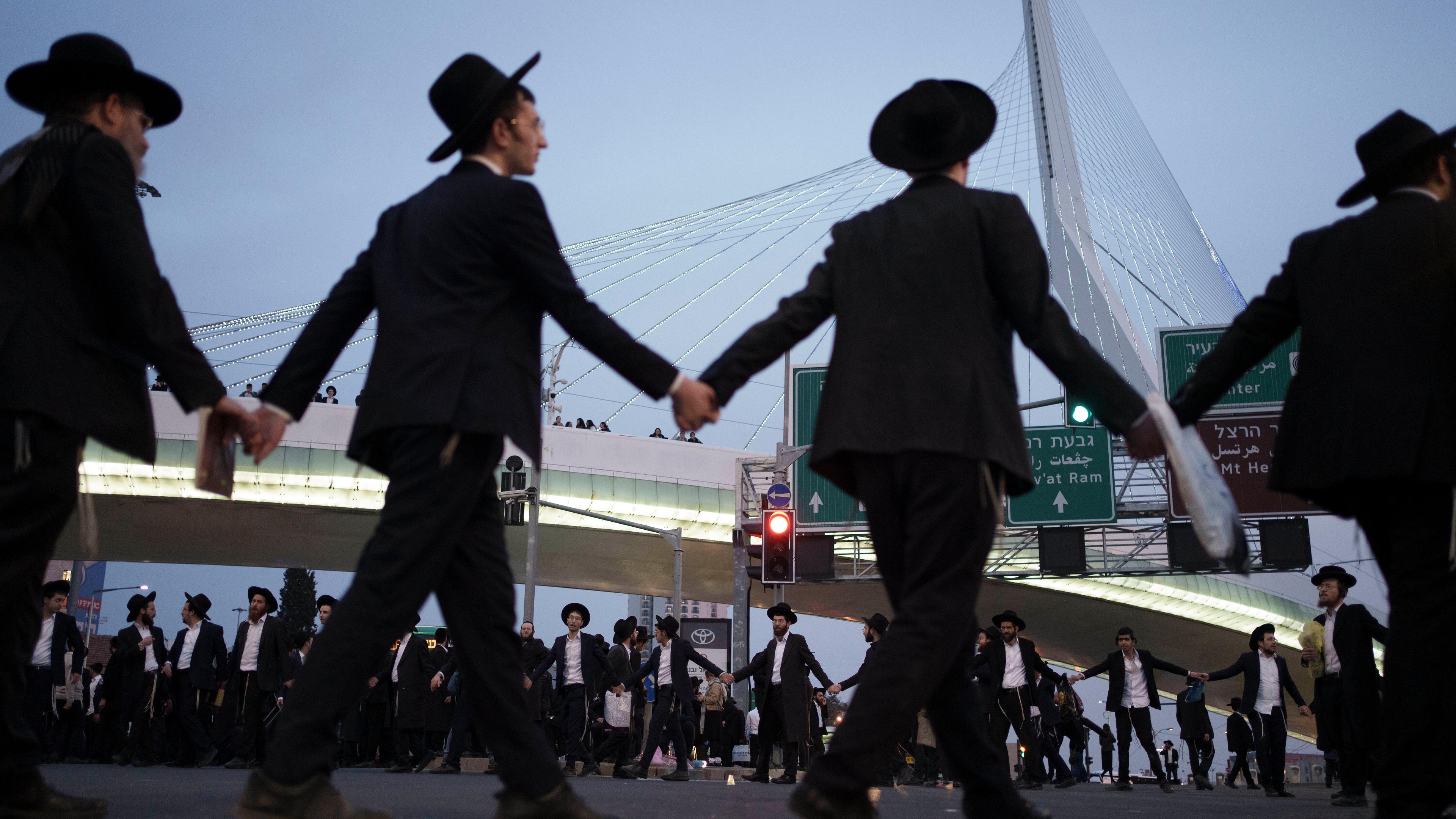 Ultraorthodoxe jüdische Männer und Jungen tanzen während einer Straßenblockade bei einer Demonstration gegen die Wehrpflicht in Jerusalem.