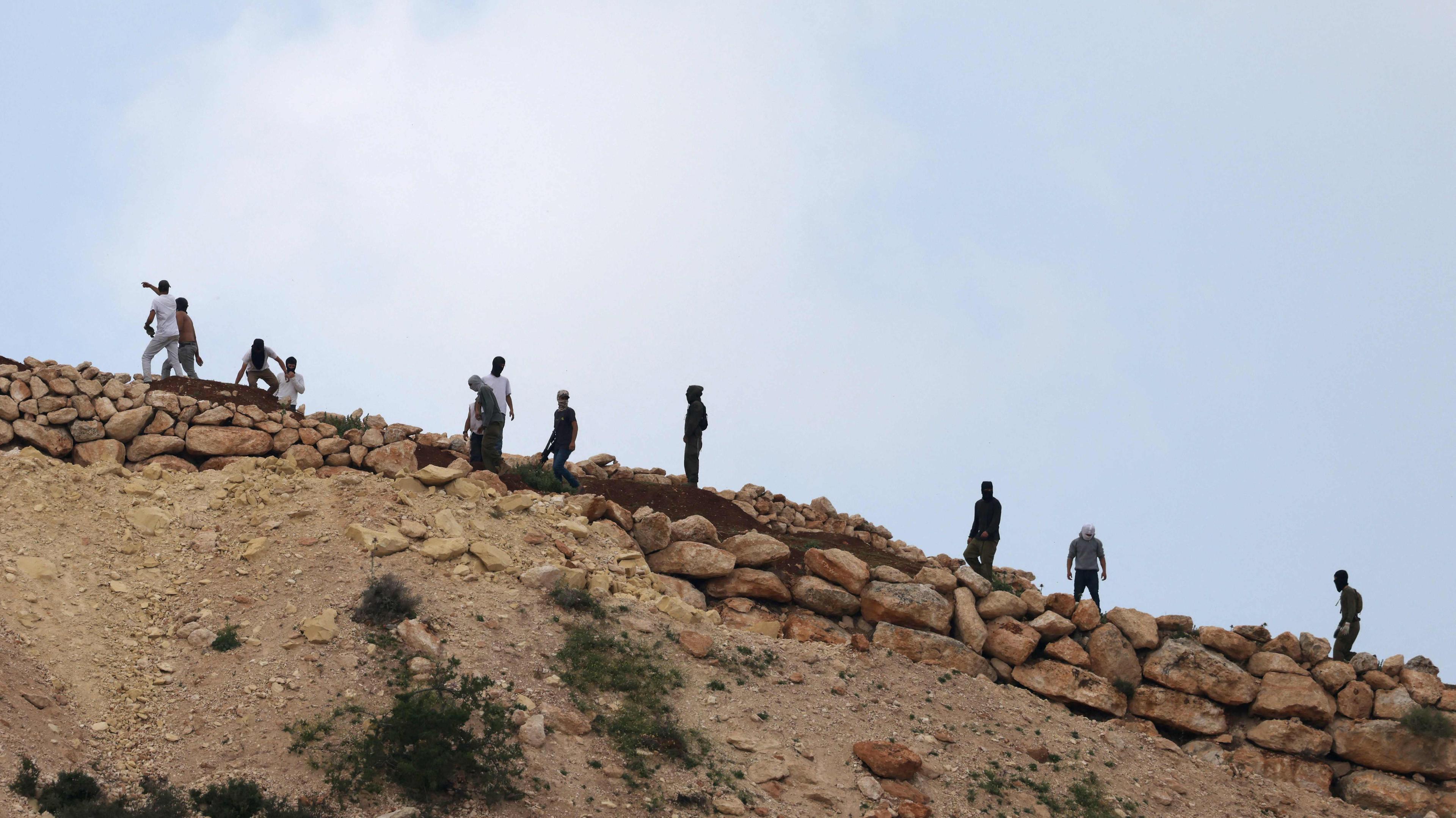 Israelische Siedler versammeln sich auf einem Hügel mit Blick auf das Dorf Mughayir in der Nähe von Ramallah im israelisch besetzten Westjordanland am 13.04.2024.