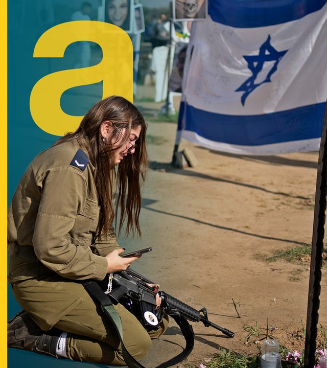 Eine Frau mit einem Maschinengewehr, die vor einer israelischen Flagge kniet.