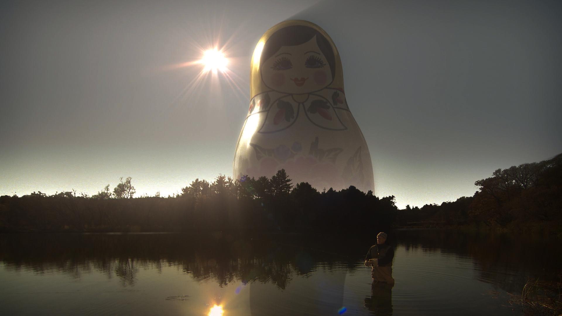 Mysterien des Weltalls: Ist Gott eine Idee von Aliens? - Russische Puppe erscheint über einem See- ein Zeichen der Mysterien des Universums.