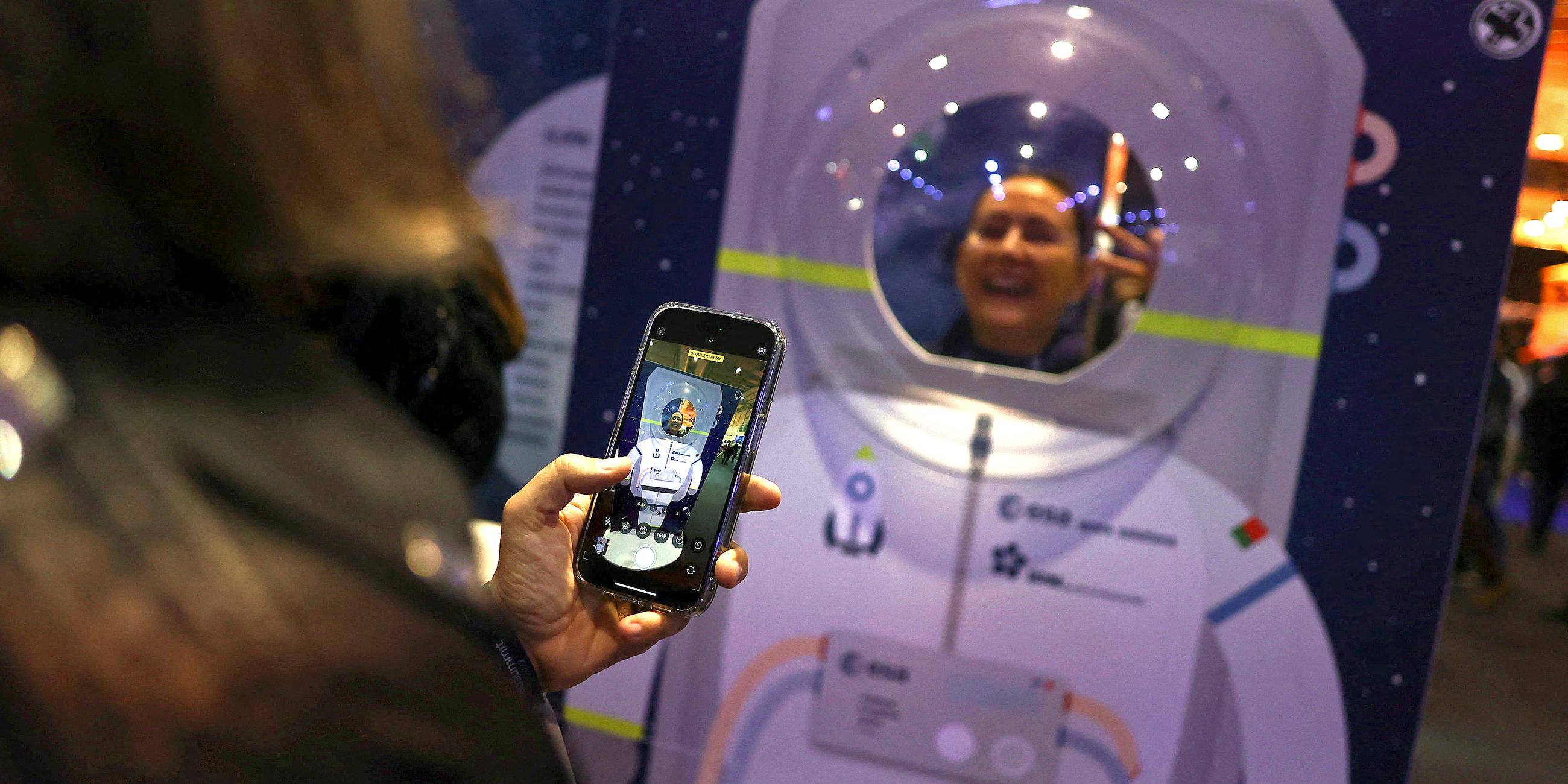 Eine Person macht ein Foto in einem Astronautenstand während des Web Summit in Lissabon (Portugal)