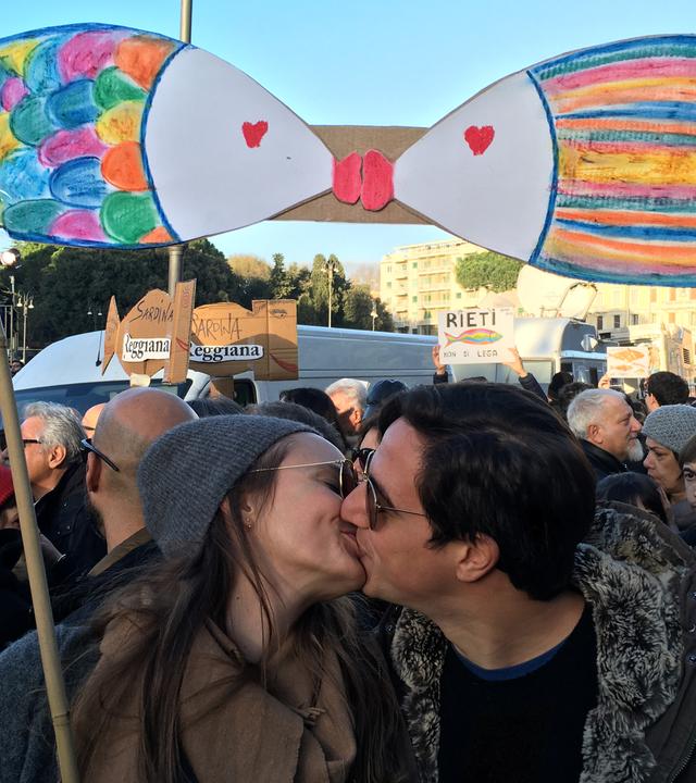 14.12.2019 in Rom: Zwei Demonstranten küssen sich unter Sardinensymbolen. 