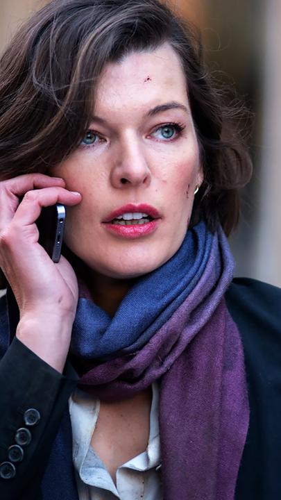 Kate (Milla Jovovich) in Nahaufnahme mit Telefon am Ohr.
