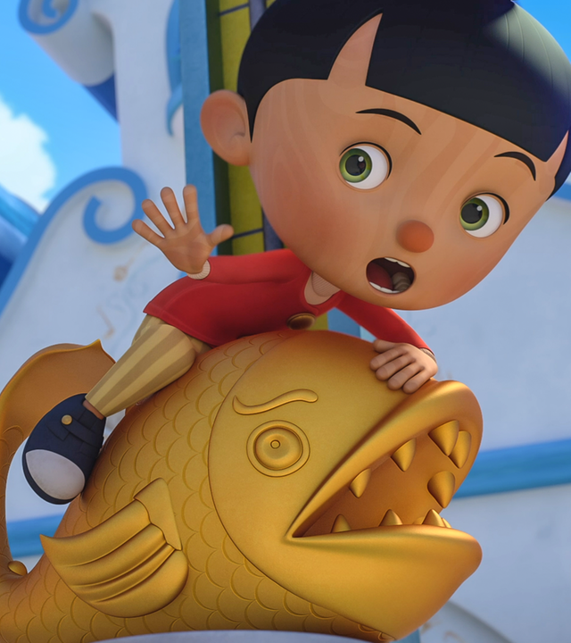 Pinocchio sitzt auf dem Glücksbringer des Dorfs, dem goldenen Fisch. Er hat seinen Mund weit aufgerissen, guckt erschrocken und streckt seine Hand aus.