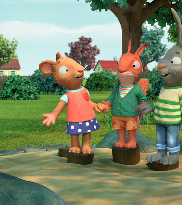 Posy und Pip stehen mit dem Eichhörnchen Jamila im Sandkasten.