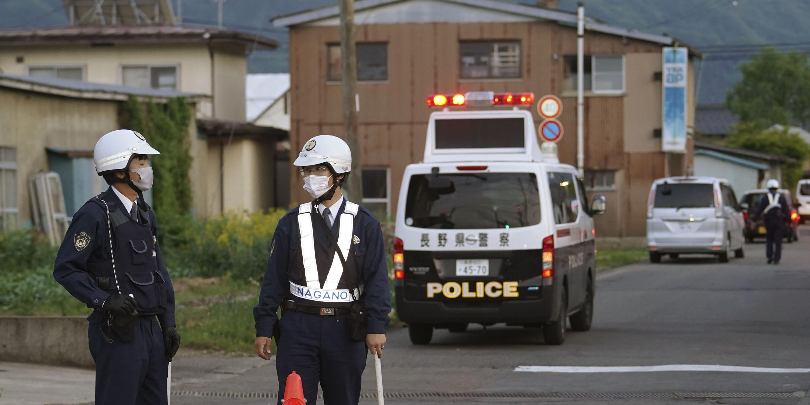 Polizeibeamte stehen in der Nähe des Tatortes in Japan.