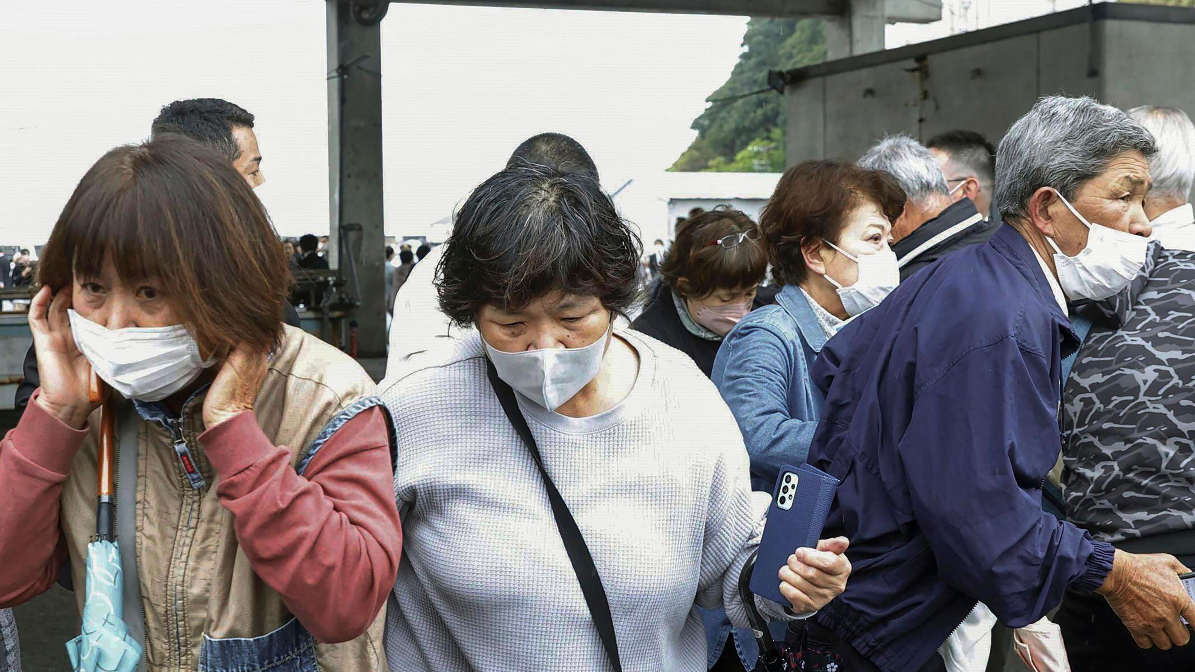 Menschen fliehen nach der Explosion einer mutmaßlichen Rauchbombe bei Kishida-Wahlkampf
