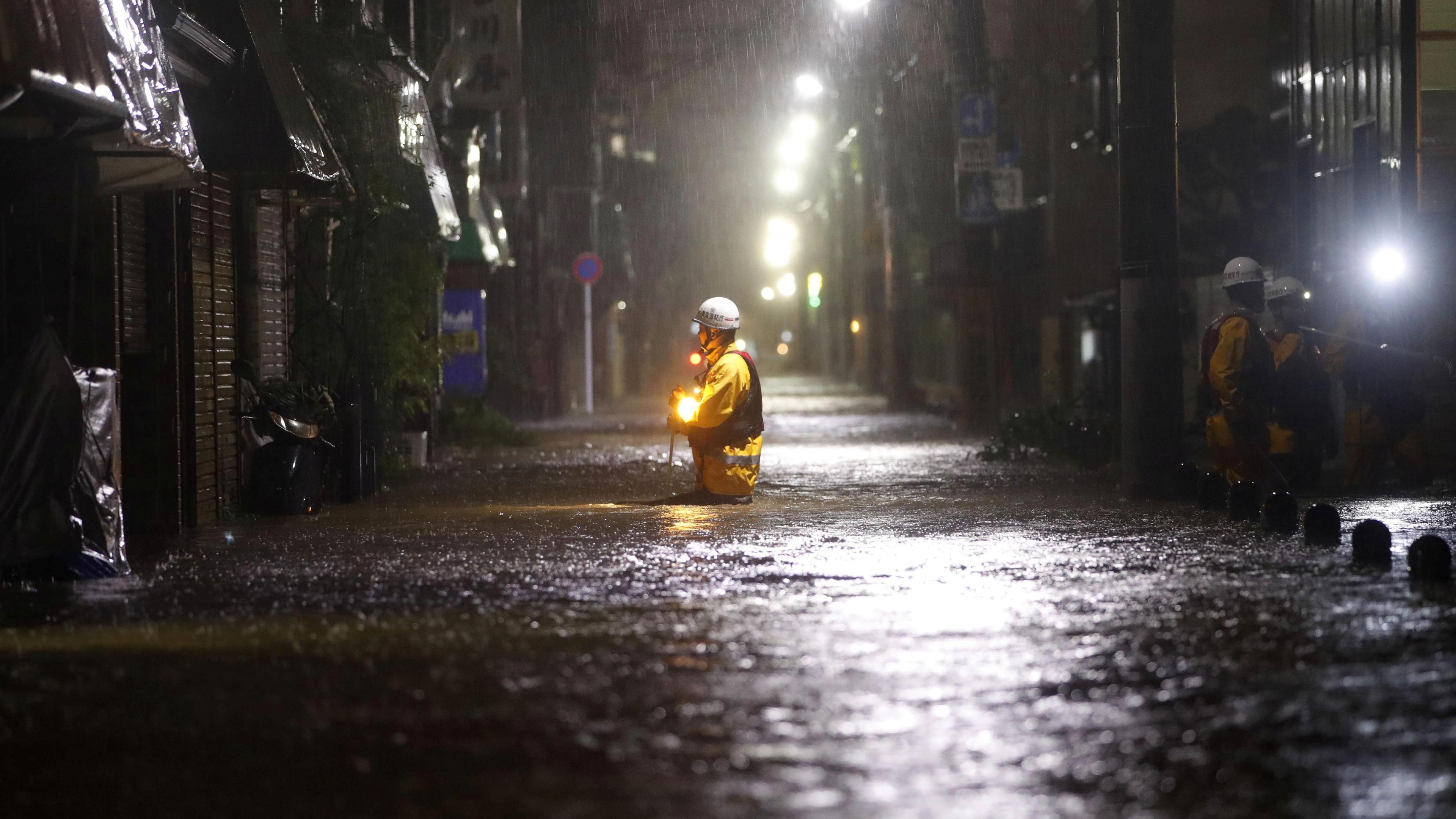 Feuerwehrleute in einer überfluteten Straße in Tokio