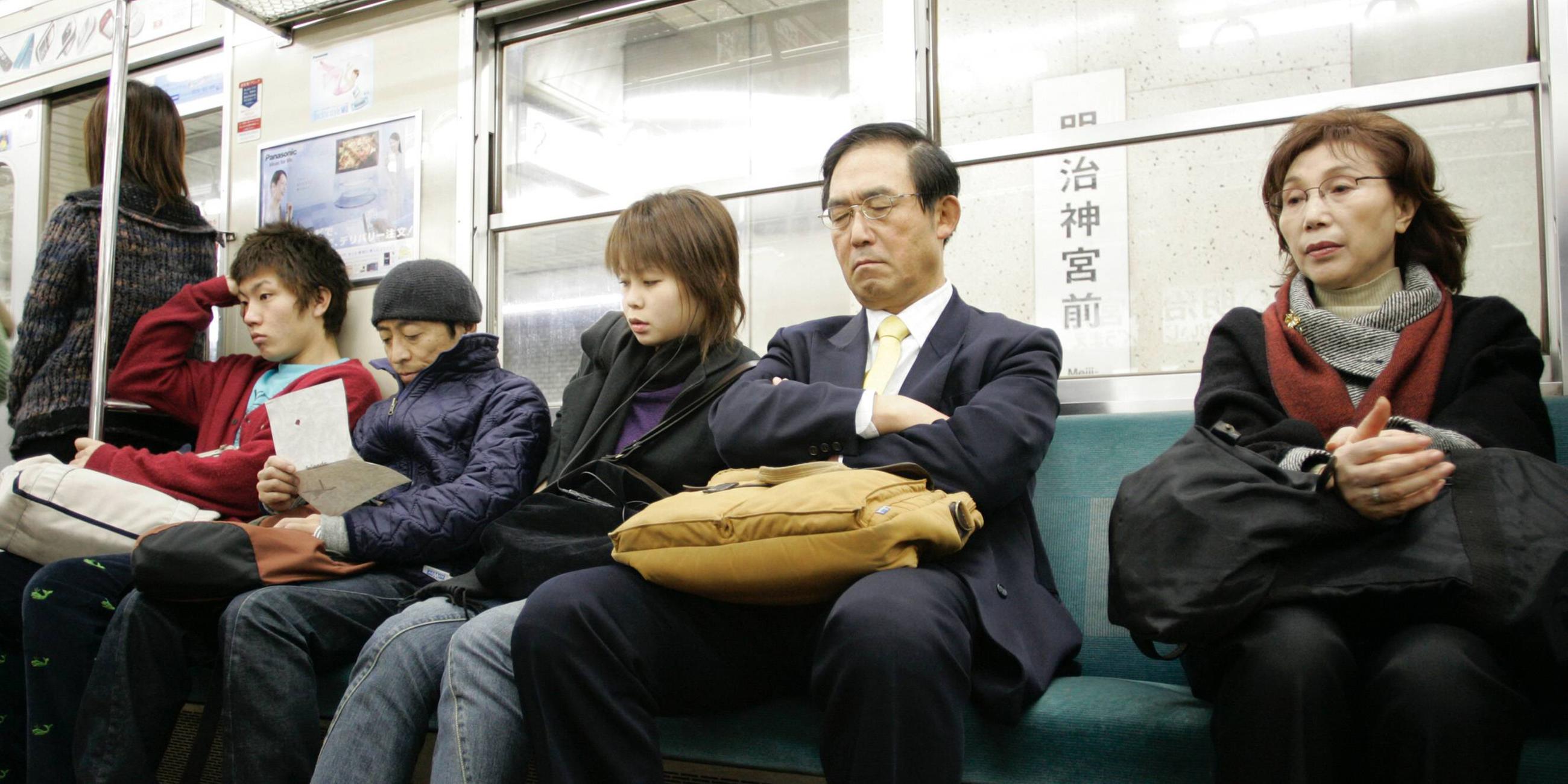 Mann in der Metro in Tokyo macht ein Nickerchen