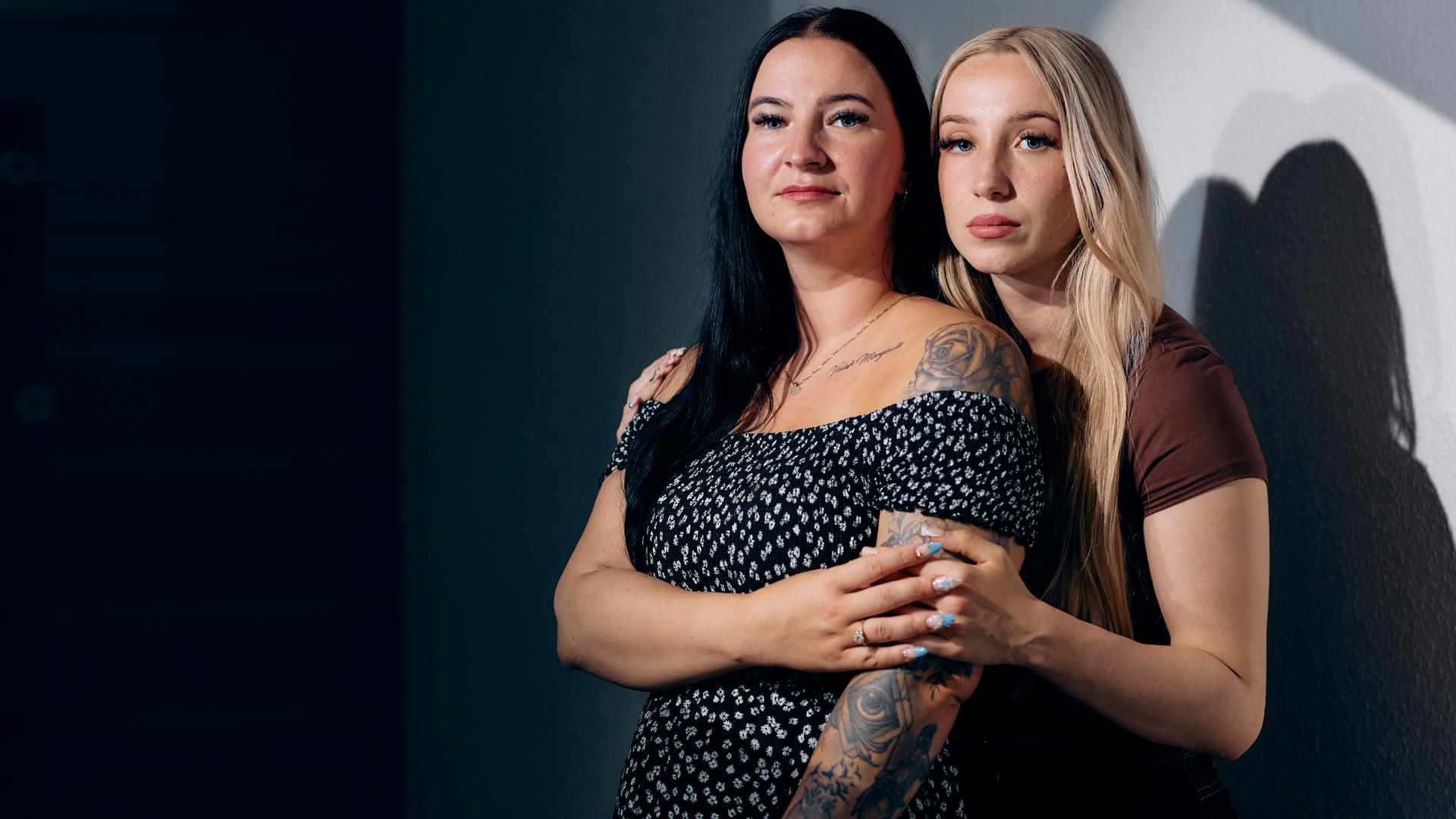 Zwei junge Frauen schauen in die Kamera. Sie scheinen eng miteinander verbunden zu sein.