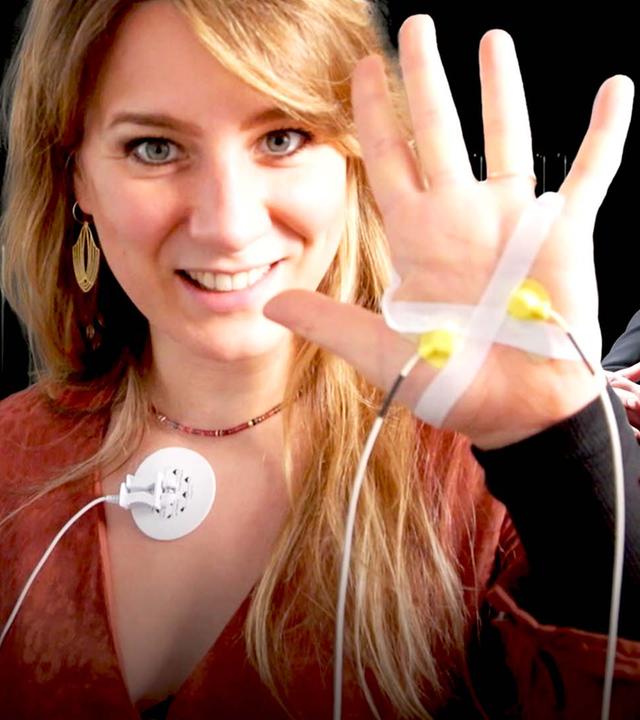 Jasmina Neudecker hebt eine verkabelte Hand