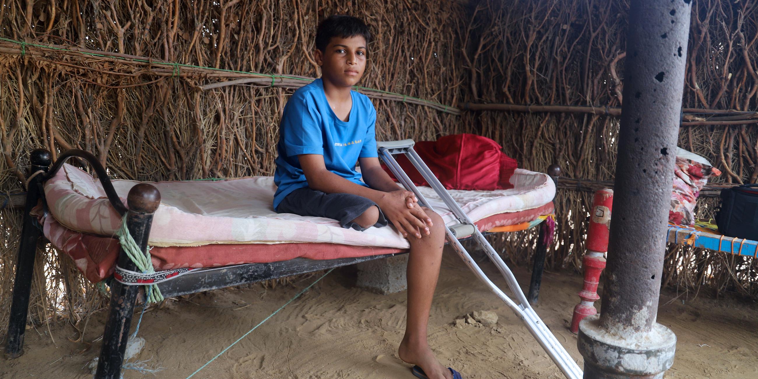 Ein Kind, das Opfer einer Landminenexplosion wurde, auf seinem Bett