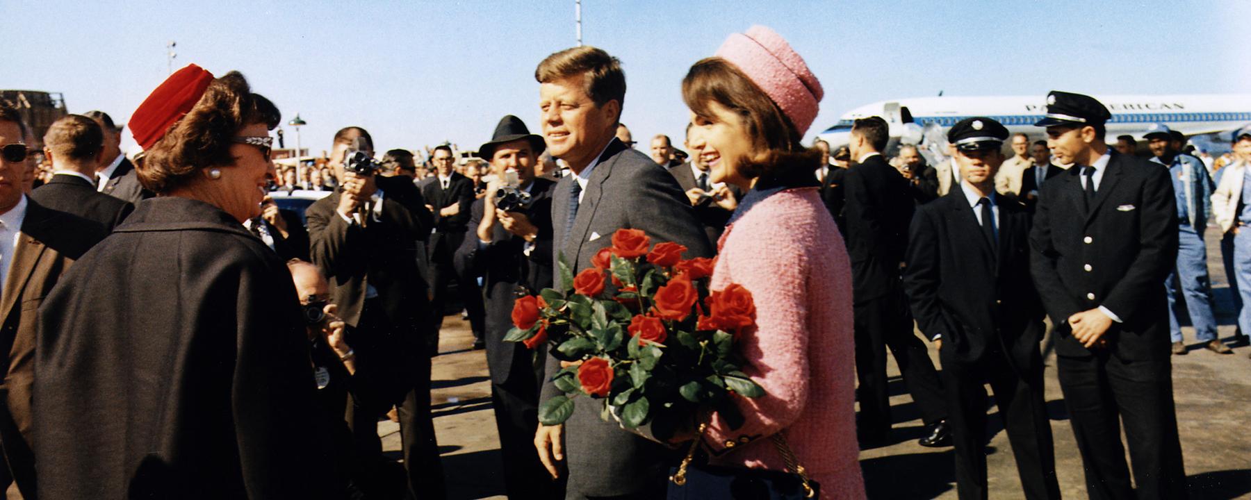 Mann und Frau laufen über das Rollfeld, im Hintergrund steht das Flugzeug.