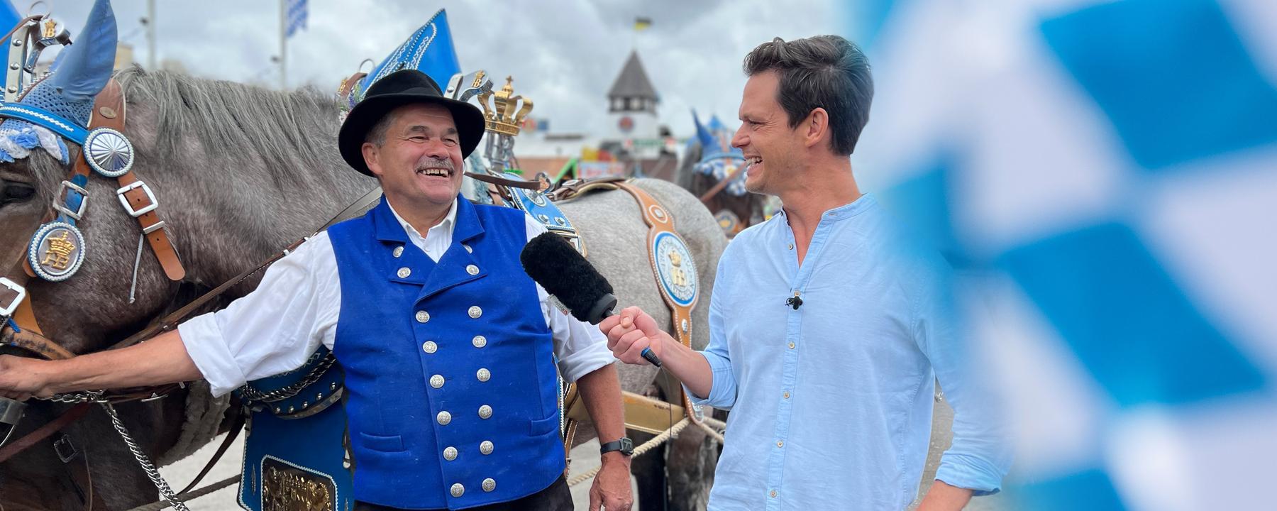 Pferd und Bierkutsche und Kutscher im Gespräch mit Moderator Jo Schück beim Oktoberfest Umzug