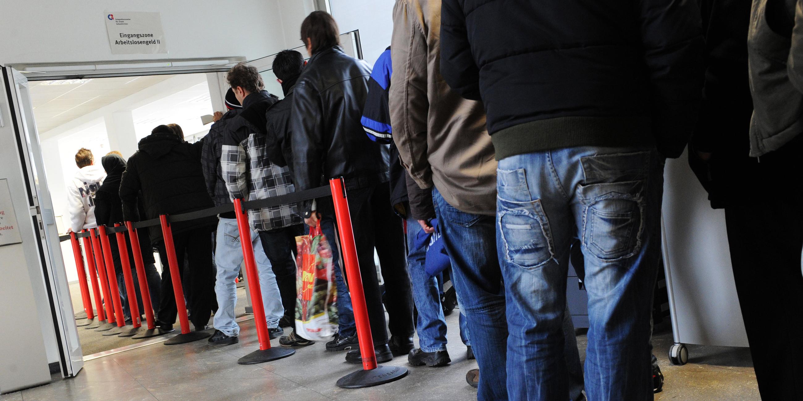 Arbeitslose warten in einer Warteschlange im Jobcenter