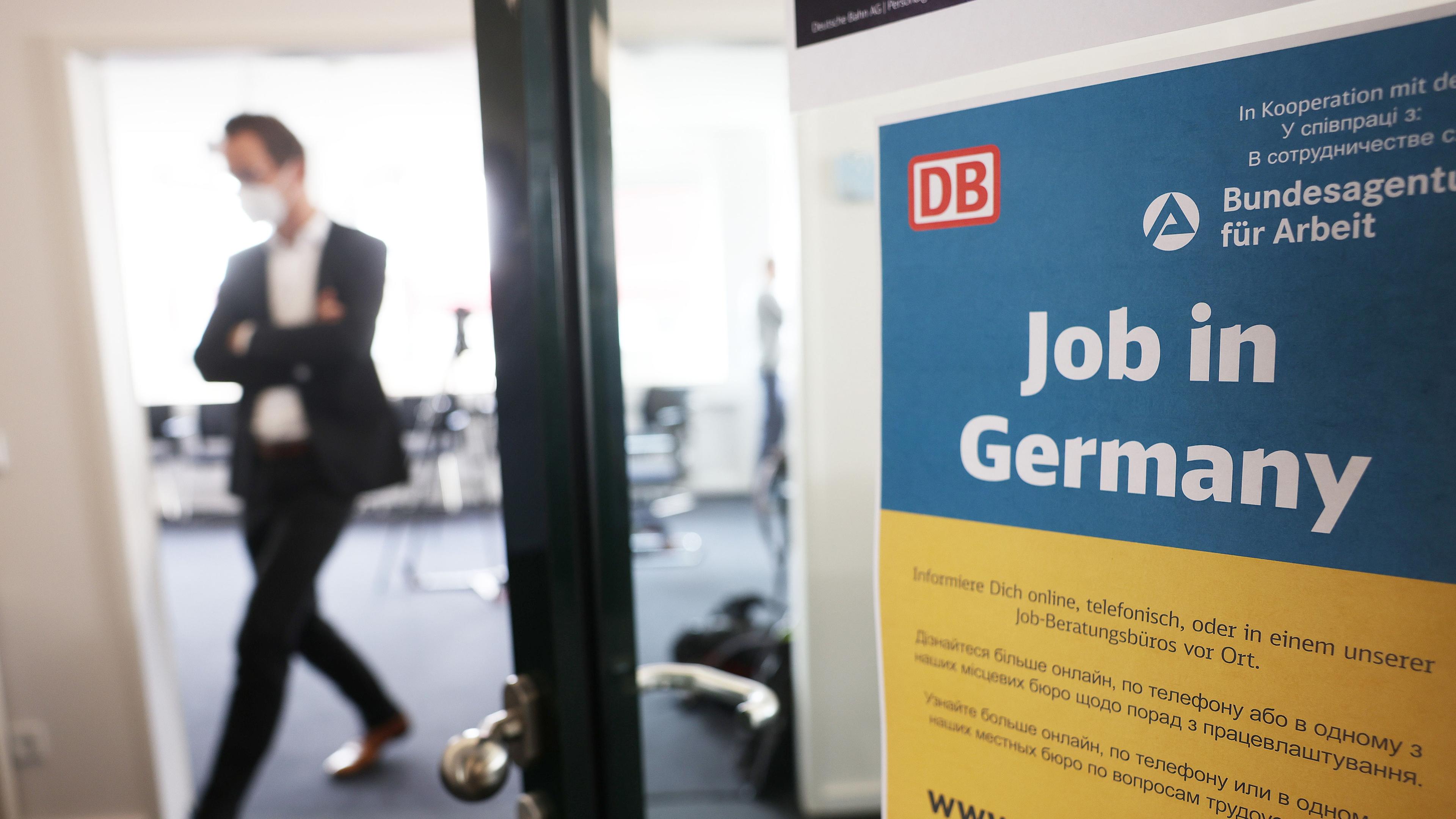 Ein Mann geht in einem Jobberatungszentrum am Hauptbahnhof an einem Plakat mit der Aufschrift "Job in Germany" vorbei