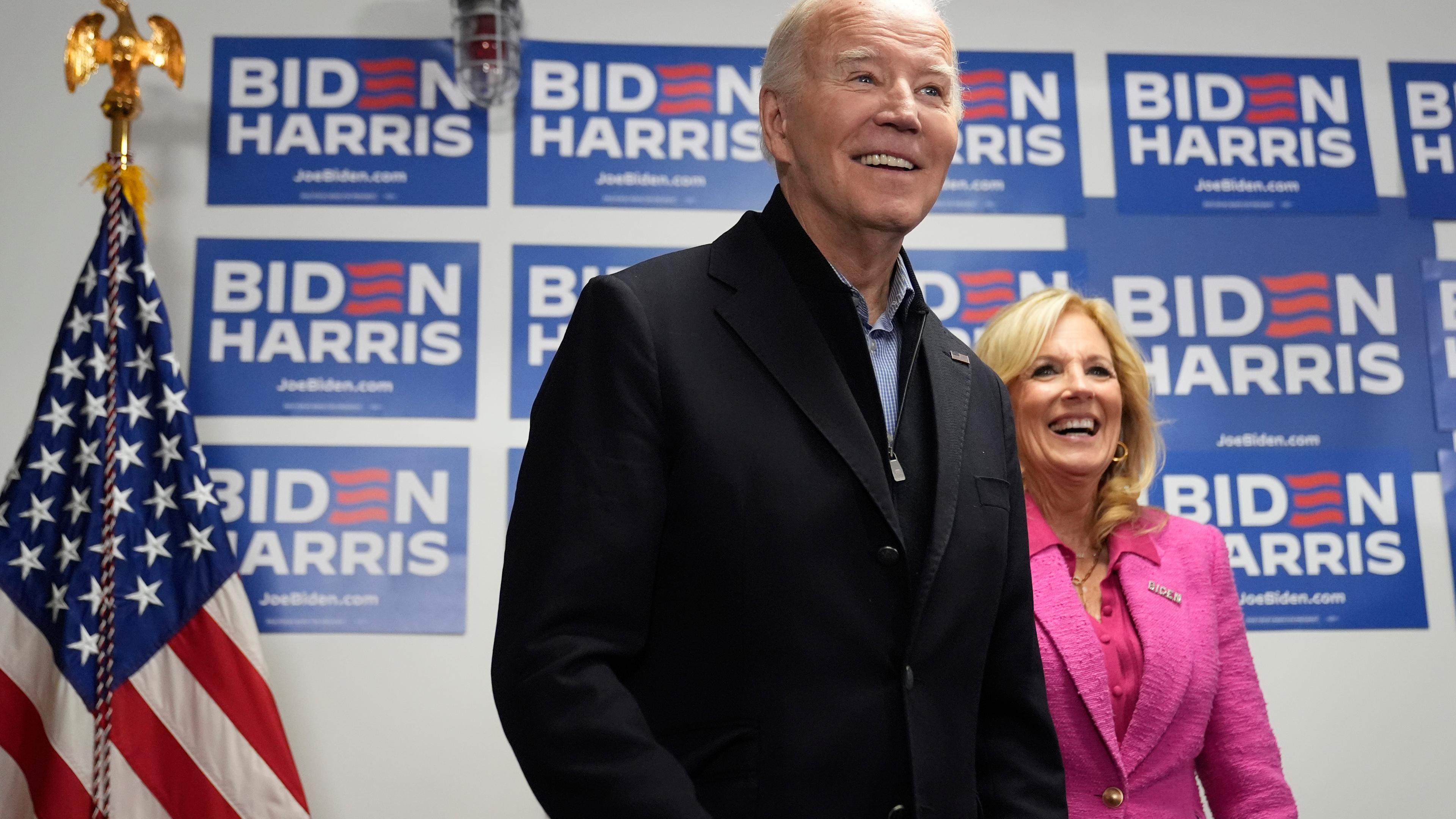 Joe Biden und seine Frau Jill Biden stehen vor einer Wand voller Biden-Harris Schilder. 