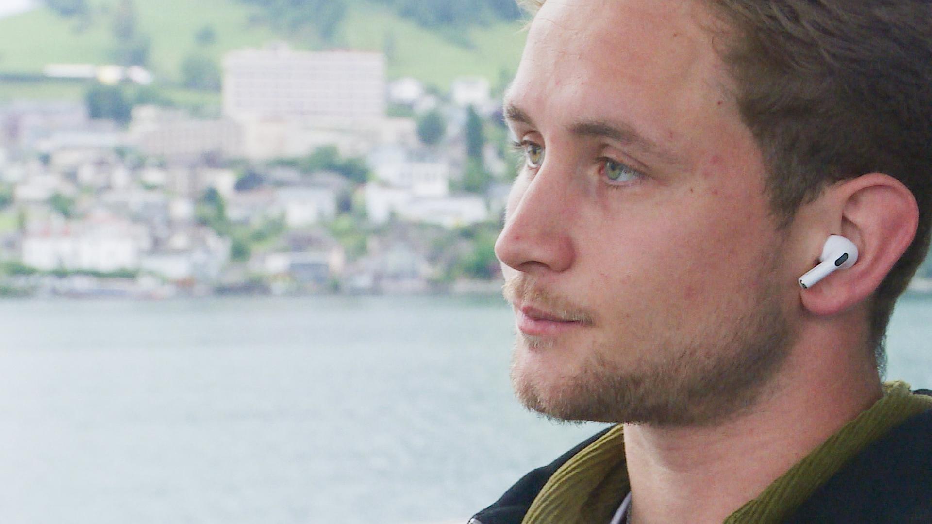 Ein Mann blickt nachdenklich, während er sich auf eine Tätigkeit konzentriert. Er ist von Barrieren in der Kommunikation durch Stottern betroffen.