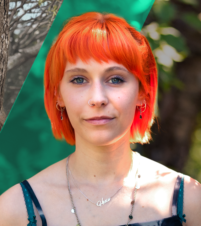 Auf der linken Seite kuschelt Johanna innig mit ihrer Schwester Mia. Auf der rechten Seite schaut sie direkt in die Kamera. Sie trägt einen knallorangenen Kurzhaarschnitt. 