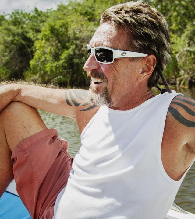 "John McAffee - Das bizarre Leben des Software-Milliardärs": John McAfee mit Sonnenbrille und Muskelshirt auf einem Boot.