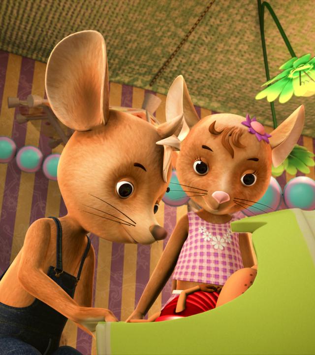 Jo und Naya stehen vor Lus Bett und schauen hinein.