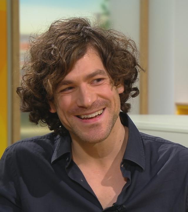 Schauspieler Jonathan Hutter lacht und sitzt im Volle-Kanne-Studio.