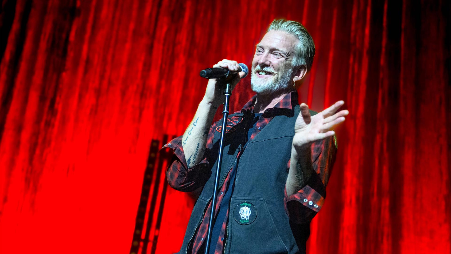 Sänger steht lächelnd auf der Bühne