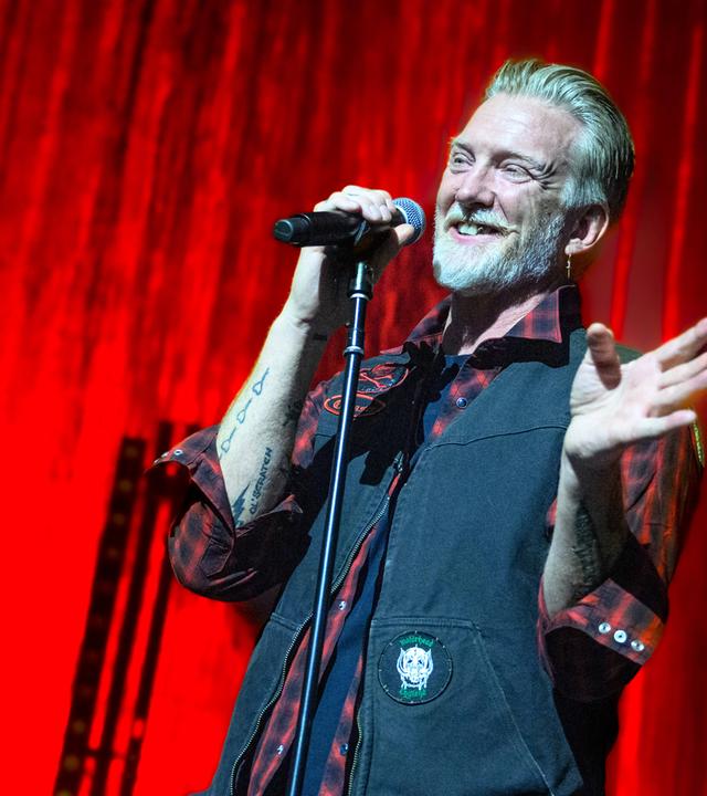 Sänger steht lächelnd auf der Bühne