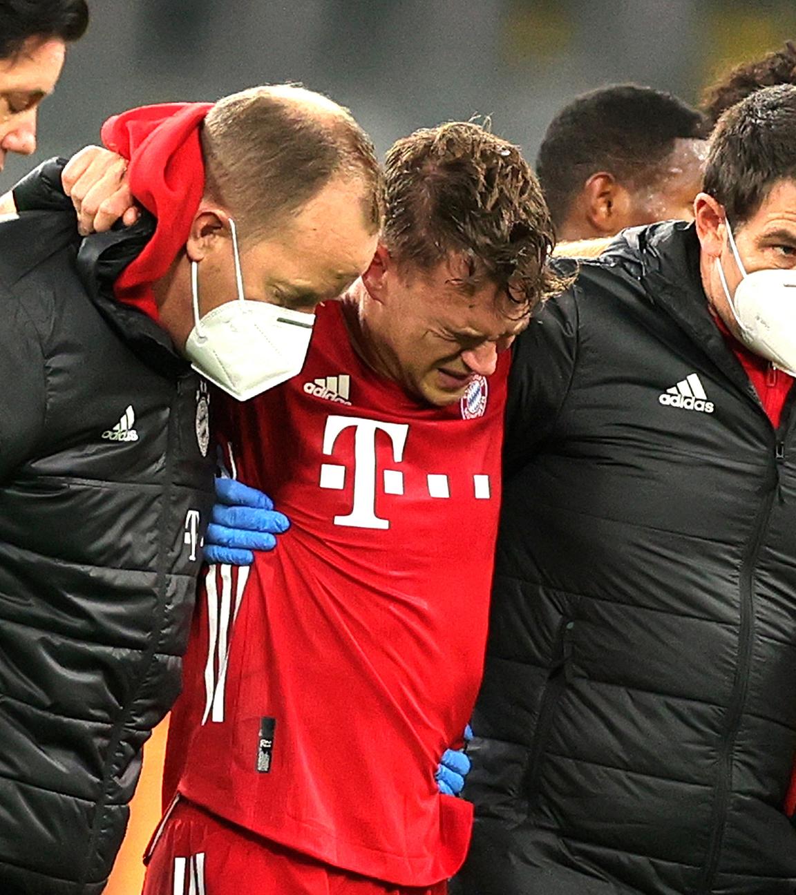 Bayerns Joshua Kimmich wird gestützt als er den Platz nach einer Verletzung verlässt.