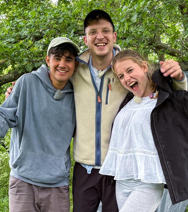 Dominik, Philipp und Pauline stehen vor einem selbst gebauten Shelter