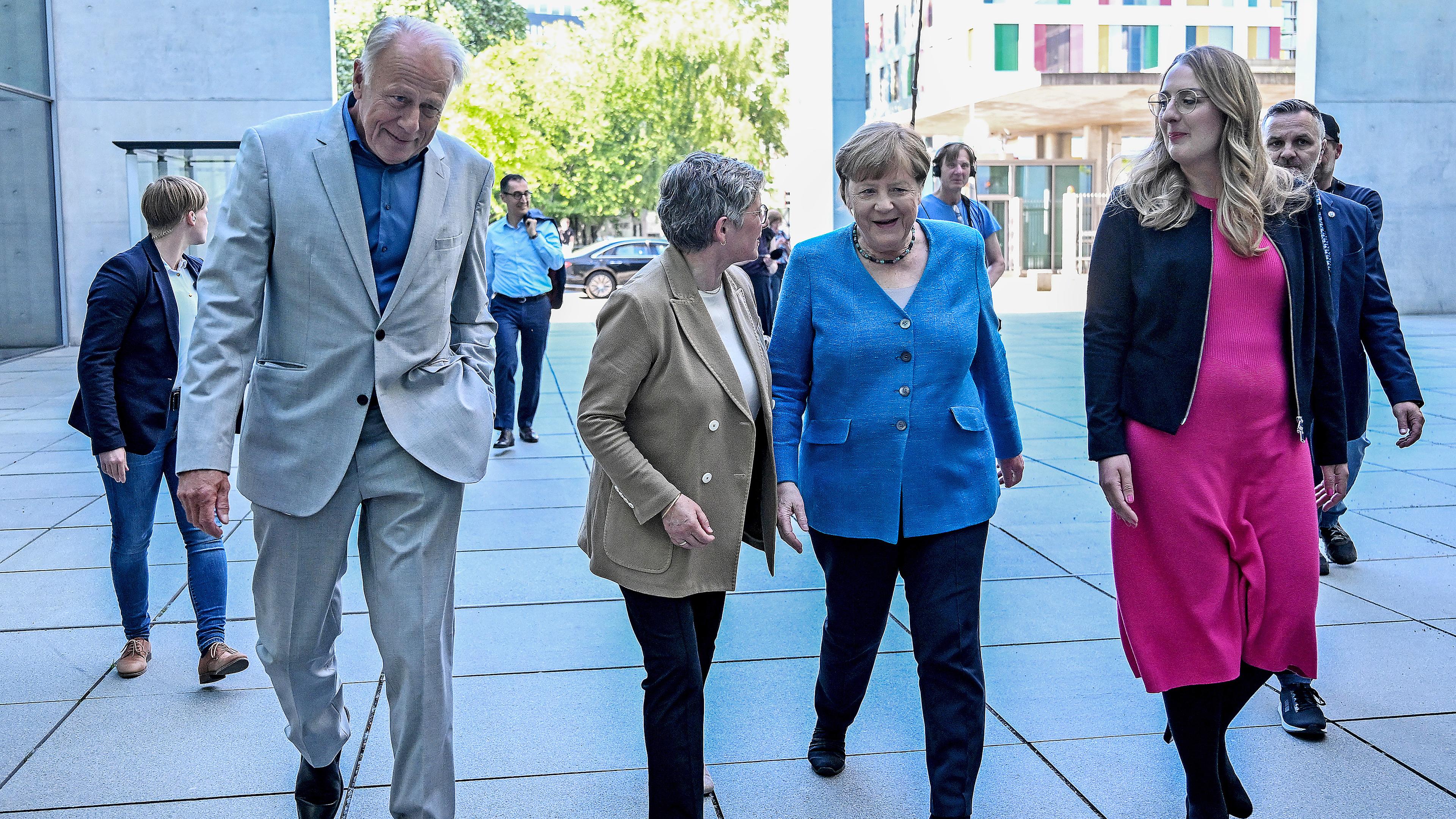 Die ehemalige Bundeskanzlerin Angela Merkel (2.v.r.) wird von Jürgen Trittin (l.), Britta Haßelmann (2.v.l.) und Katharina Dröge (r.) 