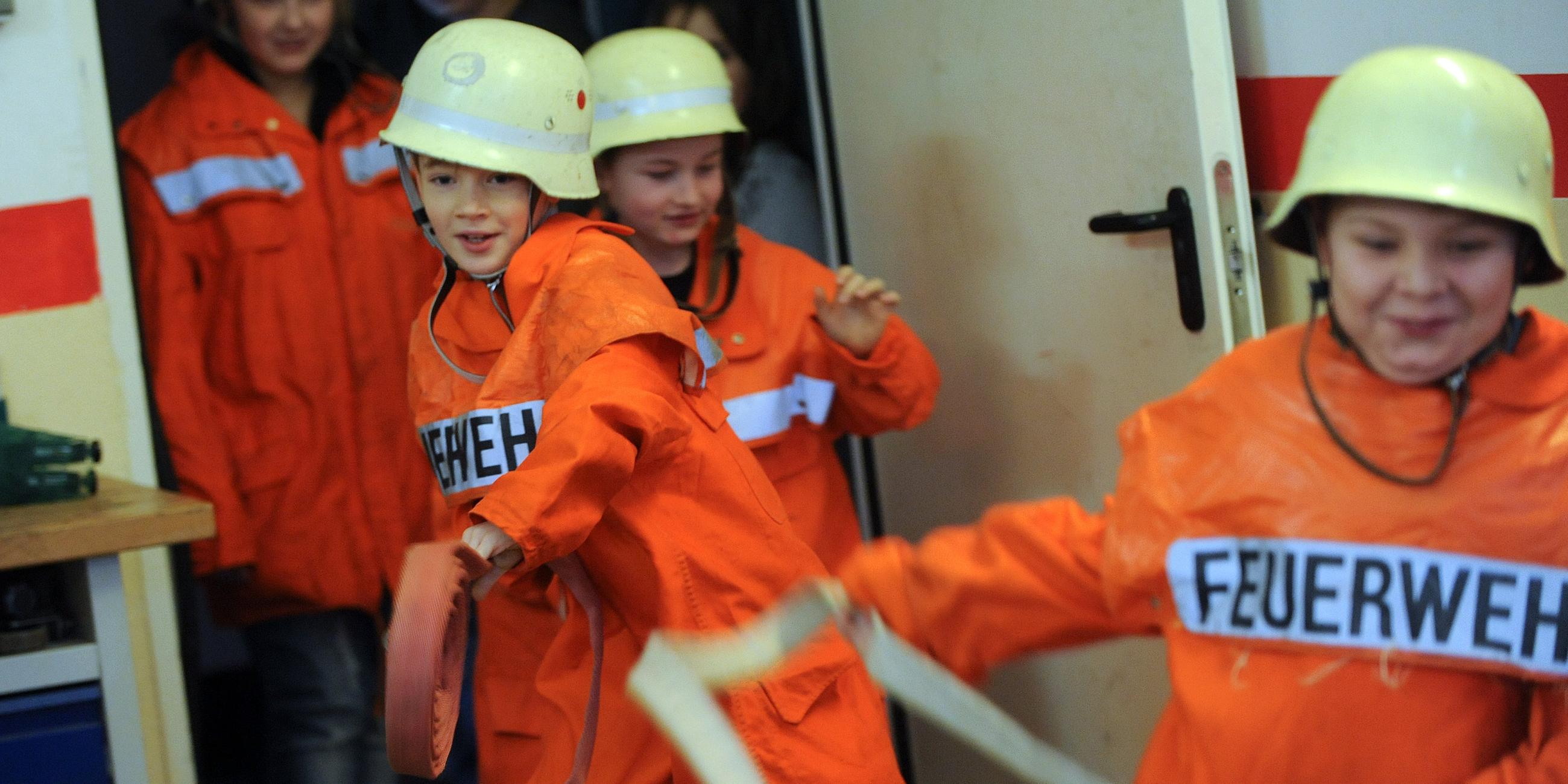 Kinder bei der Feuerwehr bereiten Übung vor.