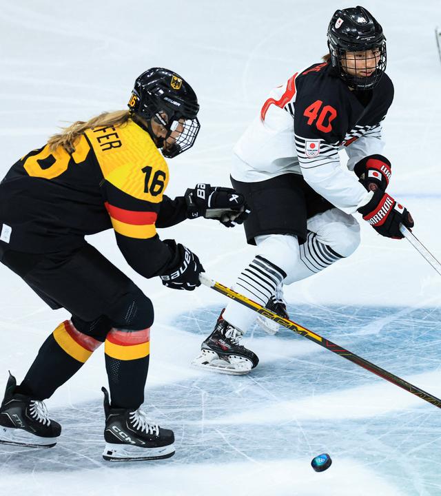 Die deutsche Eishockeyspielerin Jule Schiefer befindet sich bei den Olympischen Winterspielen im Zweikampf mit der japanischen Hockeyspielerin Rio Noro 
