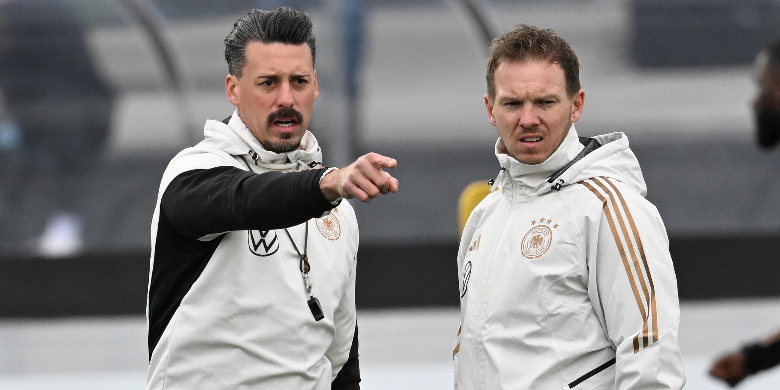 Bundestrainer Julian Nagelsmann (r) und Co-Trainer Sandro Wagner stehen beim Training der Nationalmannschaft auf dem DFB-Campus zusammen. (14.11.2023)