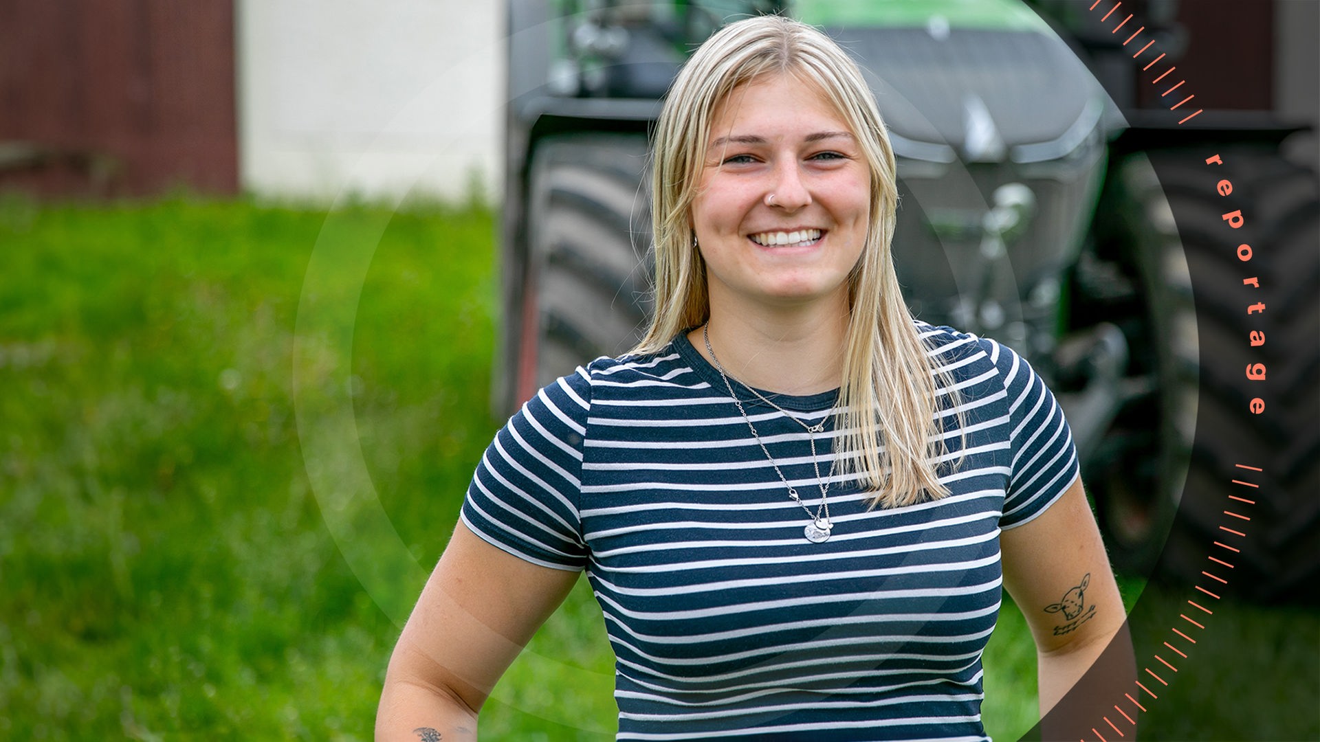 Lucy Schmidt steht lachend vor einem Traktor.