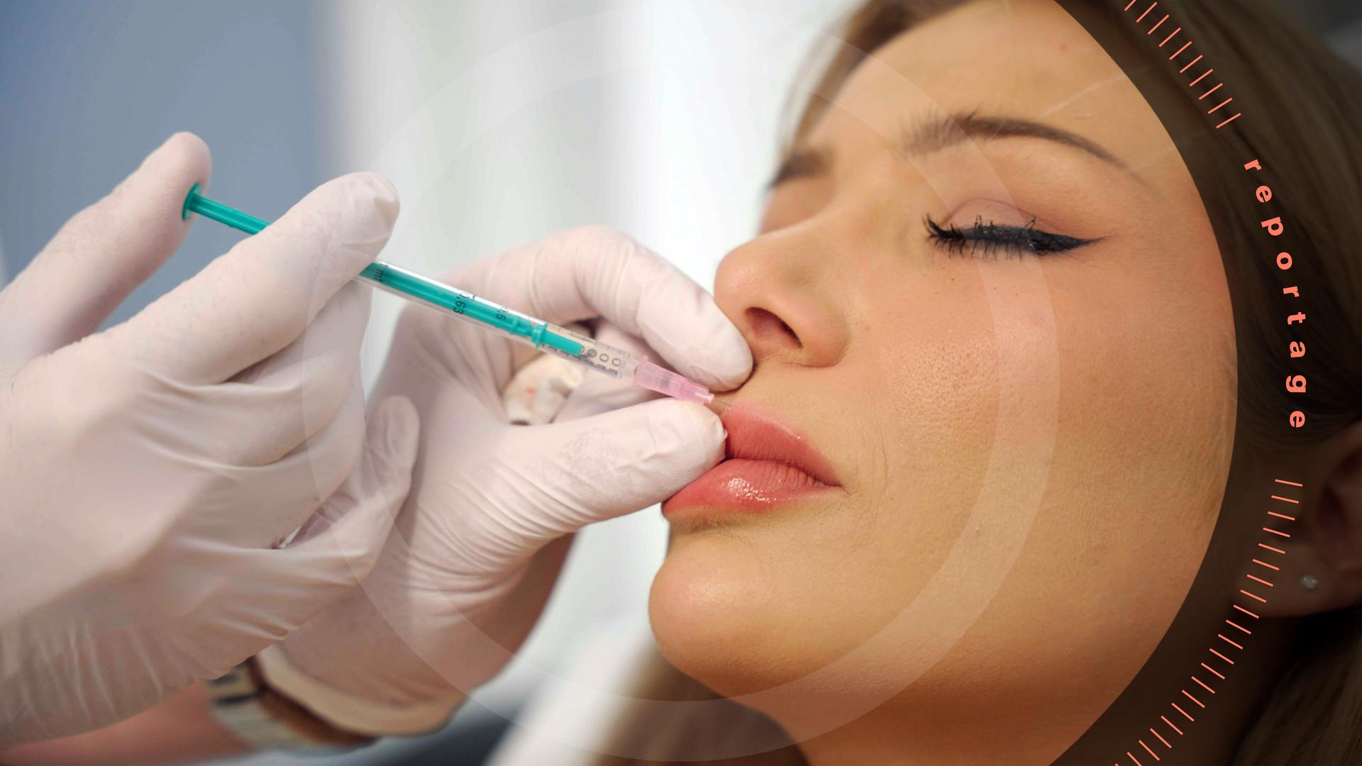 Nahaufnahme: Zwei Hände in weißen Gummihandschuhen halten eine Spritze an die Lippe von Melody Haase. Melody ist geschminkt und hat die Augen geschlossen.