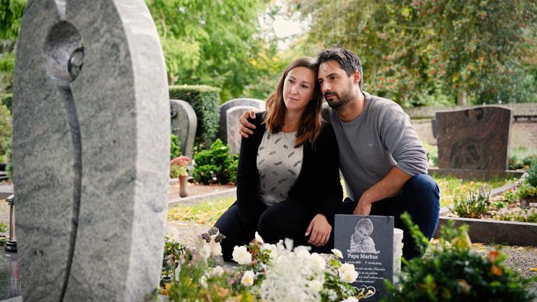 Jasmin und Serghei knien am Grab von Markus.