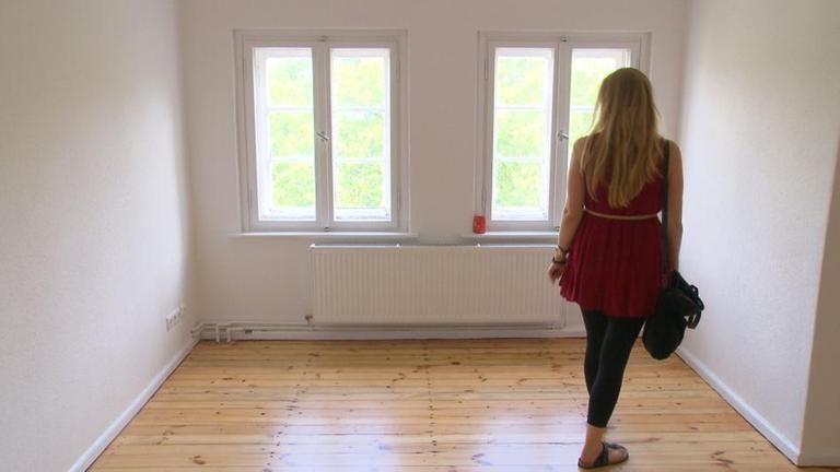 Junge Frau schaut sich eine Wohnung an.