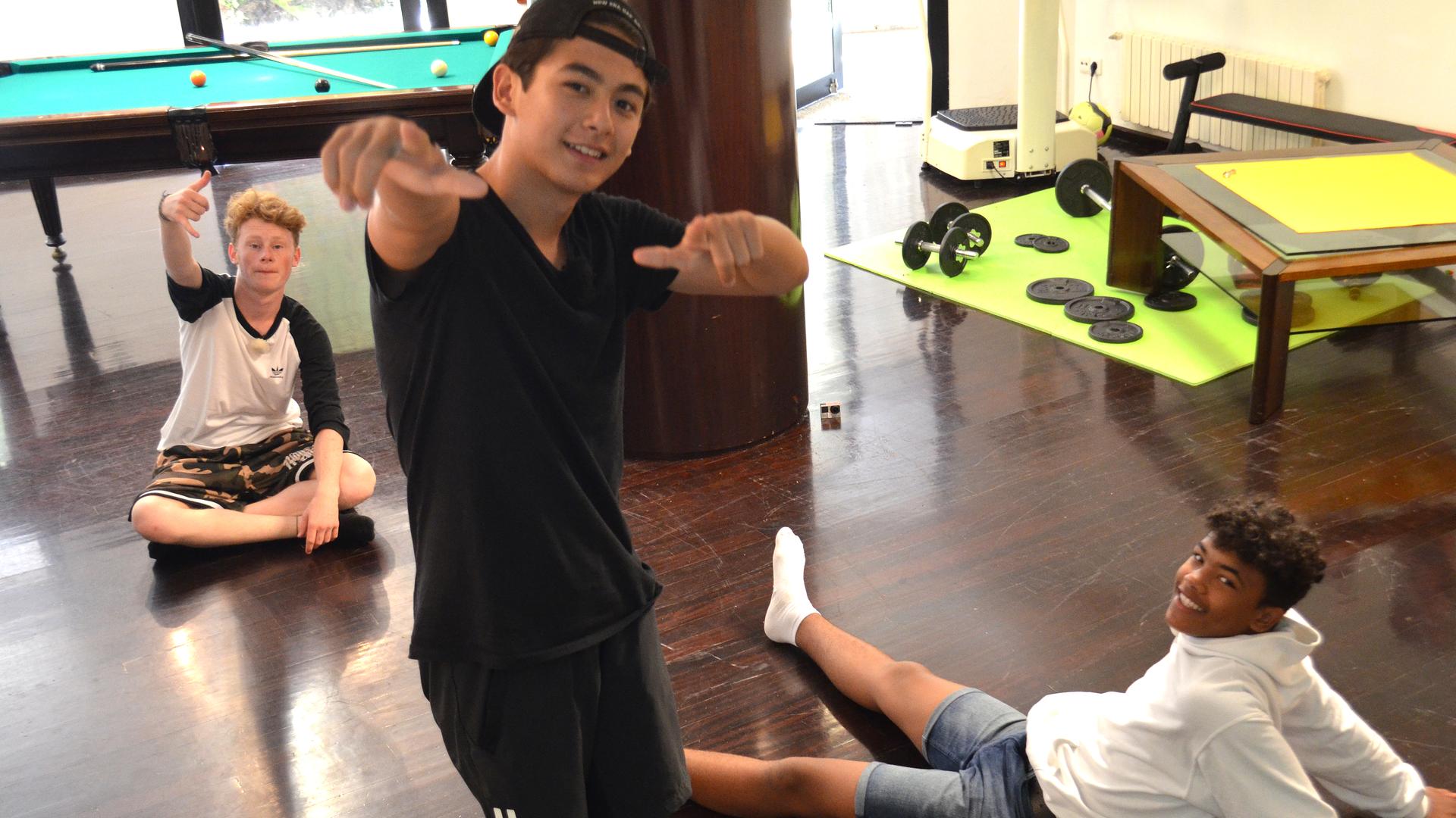 Timmy zeigt Chinedu und Justus ein paar Tricks vom Breakdancen.